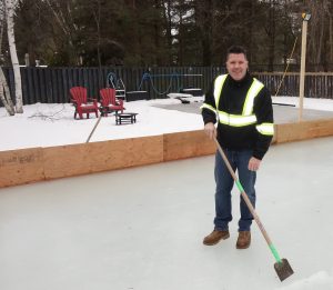 Keith Travers cleans the ice on the homemade rink